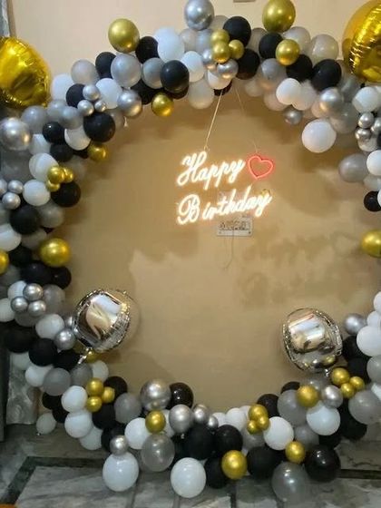 The black and gold circular balloon frame from a different angle, showing the placement of foil balloons.