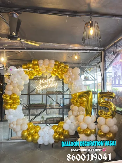 A classic and elegant 75th birthday celebration. The ring backdrop is decorated with white and chrome gold balloons, with large foil numbers.