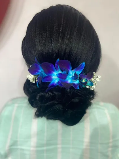 The glowing effect of the blue orchids under direct light. I love using fresh, unique flowers to elevate a classic hairstyle.
