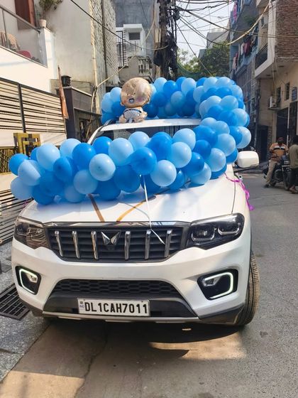 I also offer car decoration services to welcome a new baby. Here, I decorated the car with a blue balloon garland and a Boss Baby foil balloon.