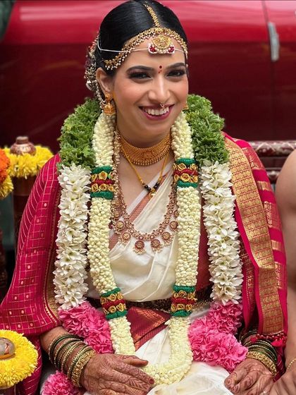 A joyful moment during the Unjal ceremony. The makeup is designed to be long-lasting and vibrant through all the wedding fun.