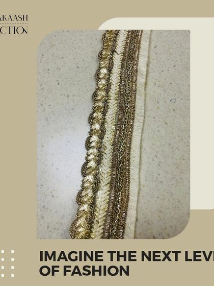 A close-up of a gold zari and threadwork lace. This type of textured, shimmering border is a classic choice for adding a touch of luxury to traditional Indian attire.