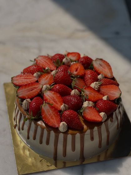 A beautiful strawberry drip cake. This cake is loaded with fresh strawberries and features a delicious caramel drip over smooth vanilla frosting.