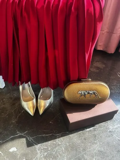 The Hailey dress in red is a perfect choice for a Valentine's celebration. This flat lay shows how I would accessorize it with gold heels, a statement clutch, and delicate jewelry for a complete, glamorous look.