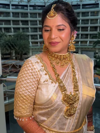 A close-up of the bride's serene look in her ivory Kanjeevaram. The drape is designed to complement her beautiful temple jewelry.