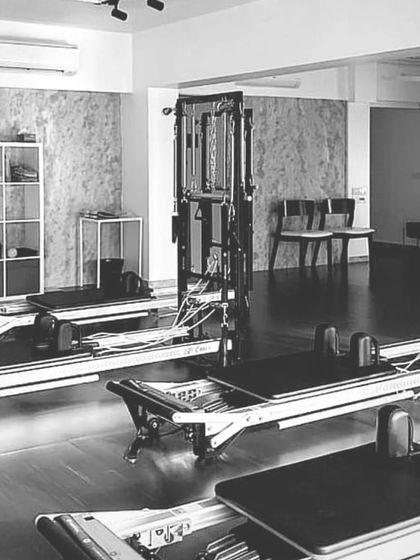 A black and white shot of our beautiful studio, showcasing the clean, modern aesthetic and top-quality reformers.