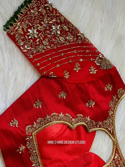 A masterpiece for our bride Madhuri. This classic red bridal blouse is heavily embroidered with zardosi and stone work, featuring a beautiful heart-shaped cutout on the back. The sleeves are a canvas of intricate floral patterns, making it a truly royal piece.