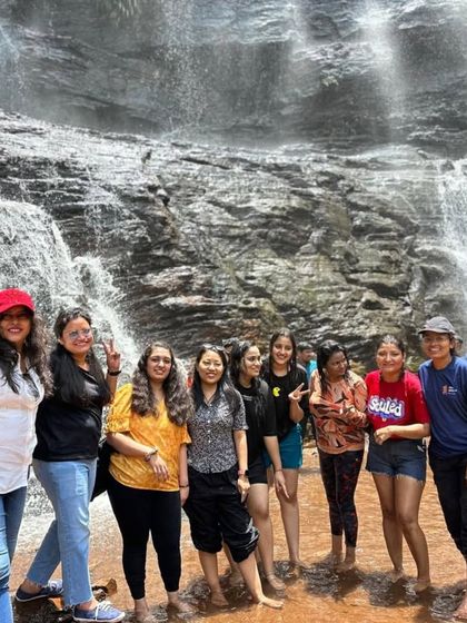 Our group of adventurers posing right at the base of Jhari Falls in Chikmagalur. The spray from the falls and the stunning rock face make for an unforgettable experience.
