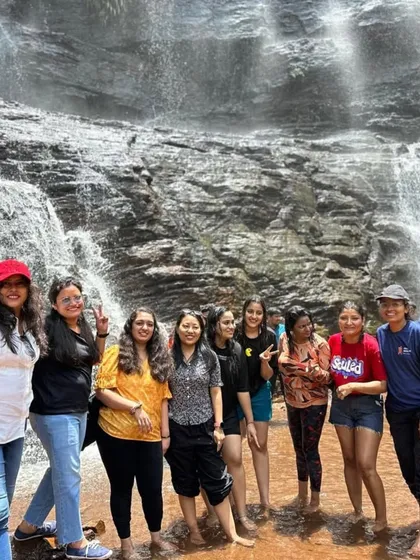 A group of women travelers enjoying the refreshing spray of Jhari Falls in Chikmagalur. We ensure a safe and inclusive environment for everyone.