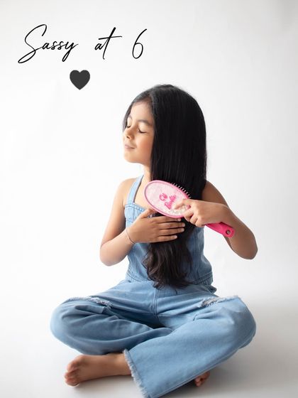 "Sassy at 6." This fun shot captures her personality perfectly as she pretends to brush her long hair.