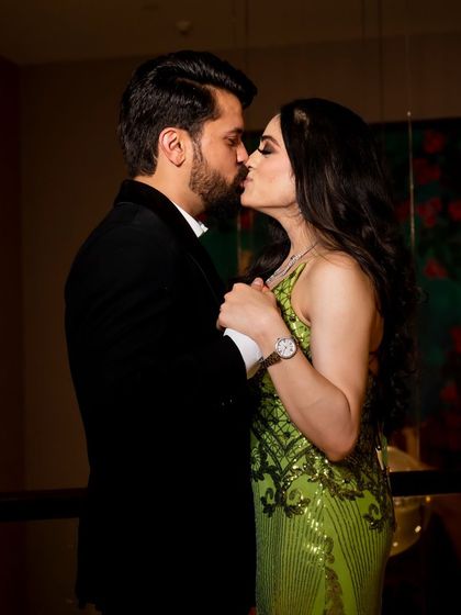 A romantic kiss, this photo captures a private, intimate moment during their engagement celebration.