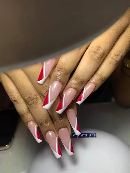 A long, coffin-shaped French manicure with a dramatic, angular design. The red and white tips create a sharp, geometric look that is both modern and bold.