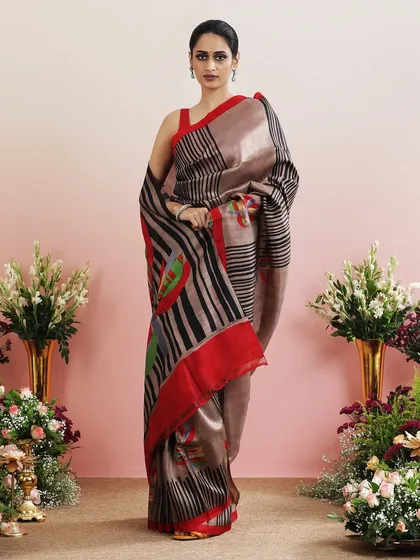 A contemporary printed saree with abstract lines and colorful floral motifs, paired with a simple red blouse.