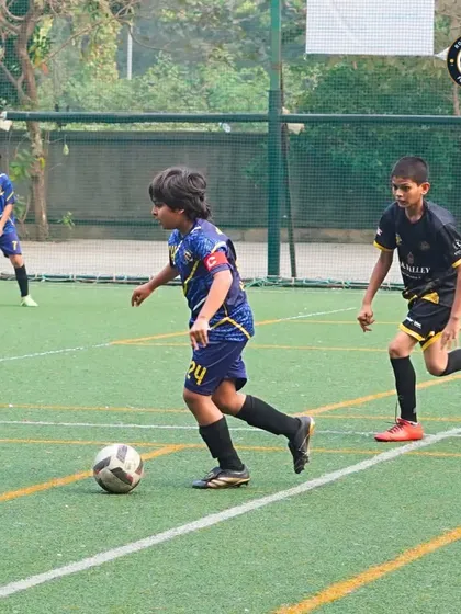 A player demonstrates excellent ball control while dribbling past a defender during a competitive match at The Winter Cup. We focus on building core skills that are effective in real game situations.