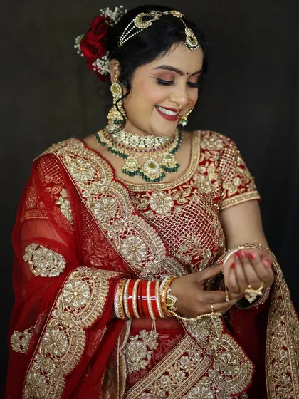 A candid moment of the bride adjusting her bangles. The makeup looks flawless and radiant, even in unposed shots.