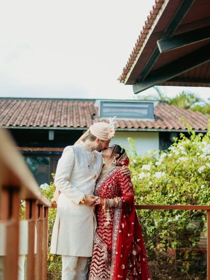 A romantic kiss shared on the balcony, a timeless and beautiful couple portrait.