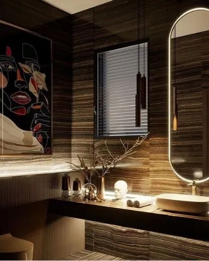 I designed this powder room to feel like a private, moody retreat. The space is defined by dark, book-matched marble walls, minimalist pendant lighting, and a custom backlit mirror that provides a soft glow. The modern art piece adds a bold, personal touch to this luxury washroom design.