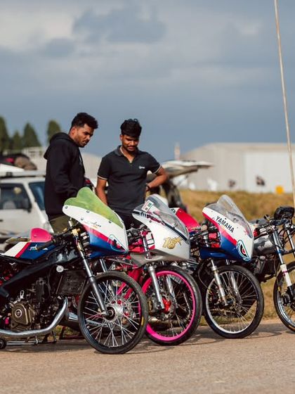 A row of colorful, custom-built drag bikes, each one a unique creation reflecting its owner's style.