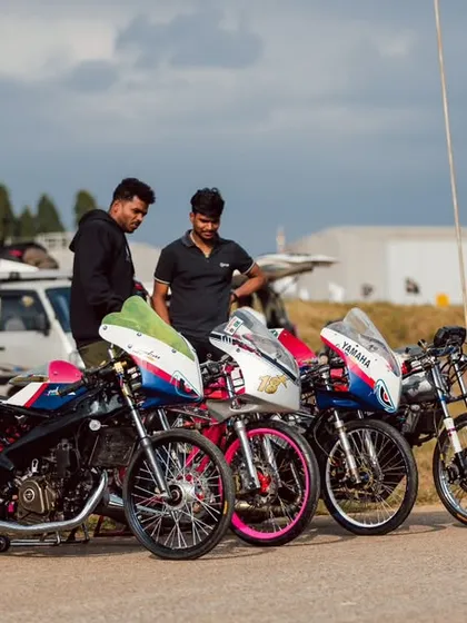 A row of colorful, custom-built drag bikes, each one a unique creation reflecting its owner's style.