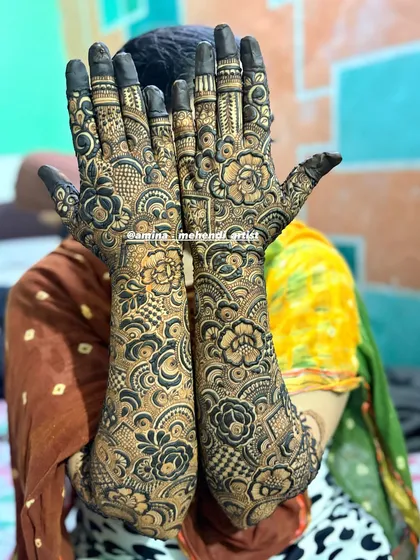 A classic "hiding the face" pose that beautifully showcases the full extent of the bridal mehendi.