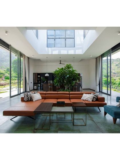 The open and airy living room of the Nandi Hills home, with floor to ceiling windows on two sides offering panoramic vistas of the verdant outdoors. The design is all about doing justice to the stunning location.