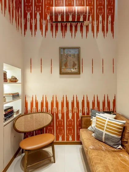 This private lounge at Ra Clinic is a cozy corner for personal consultations. The walls feature a hand painted design inspired by traditional ikat textile patterns, a collaboration with artist Hetal Shukla. The space includes a small library nook and comfortable seating, offering a quiet escape within the clinic.