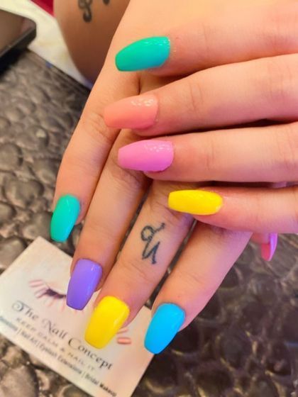 A fun and colorful set of coffin-shaped nails. Each nail is painted a different bright, solid color for a playful and eye-catching "skittles" manicure.