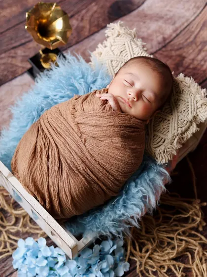 Another angle from the little gentleman shoot, this time focusing on the baby's peaceful sleeping face, nestled on a macrame pillow.