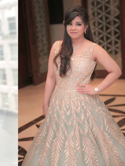 A full-length portrait showcasing the bride's stunning embellished gown for her engagement ceremony. She looks confident and beautiful.