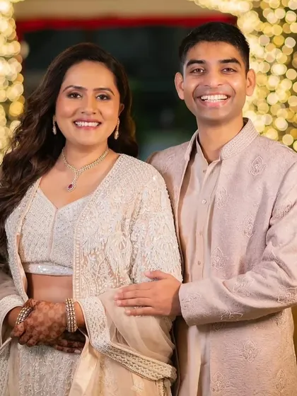 This couple's Sangeet look is pure elegance. The bride's makeup is soft and glowing, with her hair in romantic waves, perfectly matching the dreamy, fairy-light ambiance.
