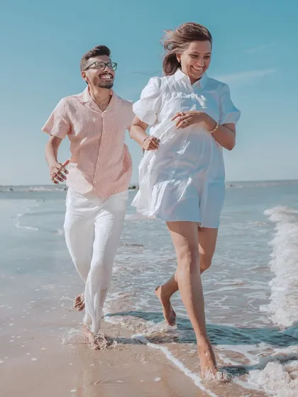 Running free by the sea. This candid shot of Harsh and Shreya captures the carefree spirit of their beach pre-wedding shoot, full of movement and genuine smiles.