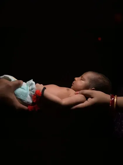 Newborn photography is about capturing the quiet, tender moments. Here, I used dramatic, soft lighting to focus on the simple, powerful image of parents' hands cradling their new baby, a memory of how small they once were.