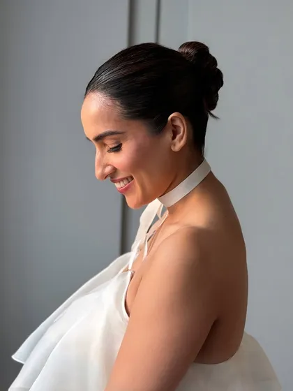 A candid moment showing the client's joy. The sleek bun is not only beautiful but also comfortable to wear, allowing you to enjoy your day.