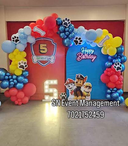 Another take on the popular Paw Patrol theme. This setup uses a red and blue backdrop with character cutouts and a balloon arch featuring paw print accents.