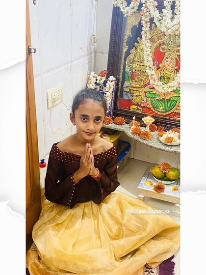 This sweet girl is ready for a festival in her custom outfit. I designed this off-shoulder top in a contrasting brown fabric to pair with a light yellow pleated skirt made from a soft, traditional material.