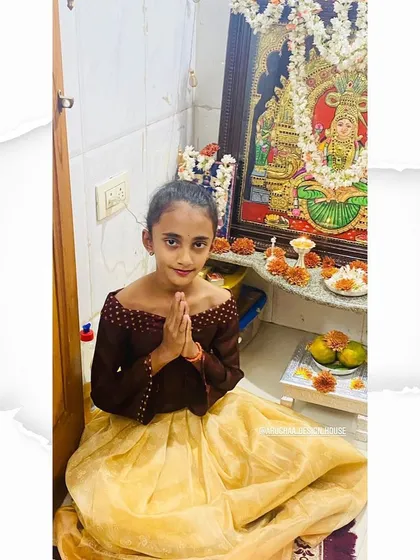 This sweet girl is ready for a festival in her custom outfit. I designed this off-shoulder top in a contrasting brown fabric to pair with a light yellow pleated skirt made from a soft, traditional material.