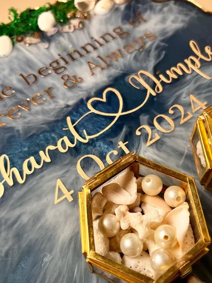 Another angle of the ocean platter, focusing on the personalized text and the hexagonal ring boxes filled with shells and pearls.