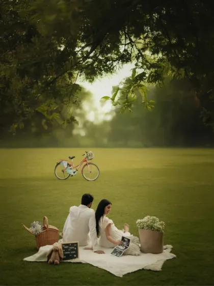 A wide shot of the romantic picnic setup, with a vintage bicycle adding a whimsical touch. This image showcases the beautiful, expansive outdoor locations we use for our styled shoots.