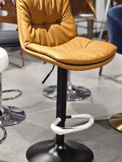 This is a premium revolving bar stool with a comfortable, tufted tan leatherette seat. The height is adjustable, making it suitable for various counter heights.