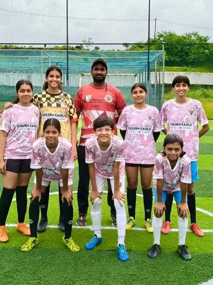 Our fresh and new girls' team posing with their coach. We are always excited to welcome new players and build the next generation of female footballers.