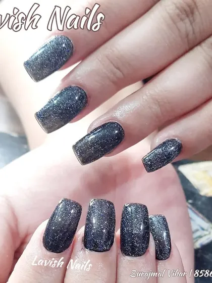 A full set of square nails with a dark, shimmery black glitter polish.