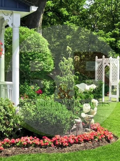 A classic English-style garden design. This front yard features abundant flowerbeds with colorful blooms, neatly trimmed hedges, and charming garden statues, creating a welcoming and picturesque entrance.