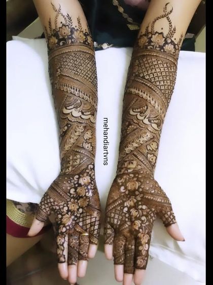 A full-arm design with swirling patterns, floral details, and delicate net-work. This style of mehandi provides complete and beautiful coverage.
