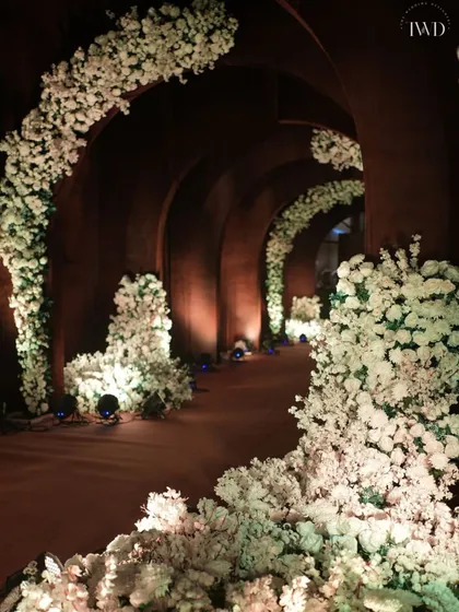 For a 'Midsummer Night's Dream' Sangeet, we constructed this dramatic arched tunnel. The dark, earthy structure was adorned with contrasting white flowers, creating a mystical and enchanting pathway for guests.