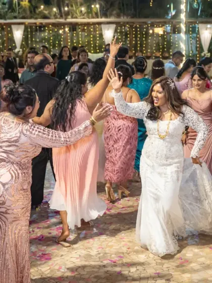 Let's get the party started! I'm right there on the dance floor with you, capturing the energy and joy of the celebration. This shot shows the groom and guests joining the bride for a fun, candid reception moment.