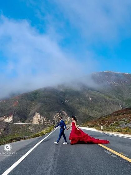 An iconic road shot from a pre-wedding shoot in the US. The vibrant red of the gown creates a stunning pop of color against the misty mountains and open road, proving my outfits travel well.
