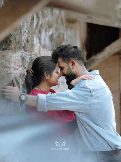 An intimate embrace against a stone wall, the couple lost in their own world.
