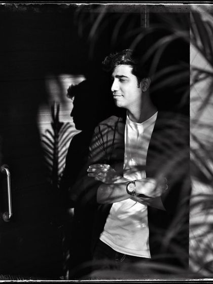 Anhad, with palm shadows creating a beautiful pattern of light on him. This 'Doorways' shot plays with reflections and natural elements.