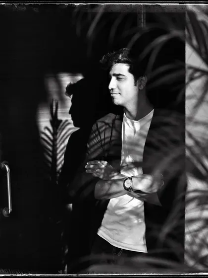 Anhad, with palm shadows creating a beautiful pattern of light on him. This 'Doorways' shot plays with reflections and natural elements.