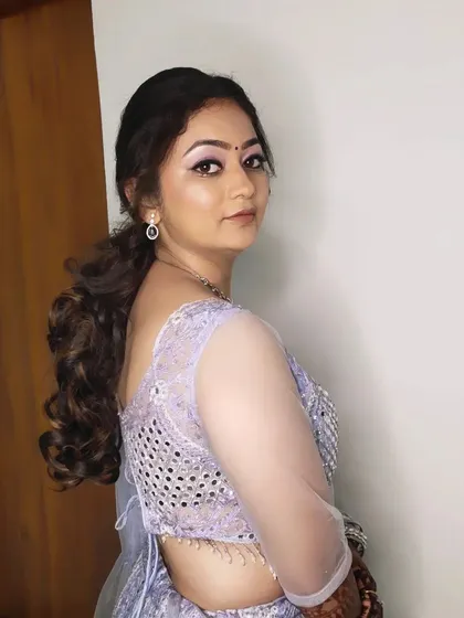 A side view of this sangeet look, showing the bouncy, curled ponytail and the soft, glowing makeup.